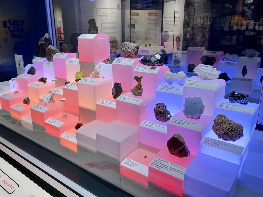 An image of an exhibition display showing minerals from around the world containing all 65 elements found in the average cellphone.